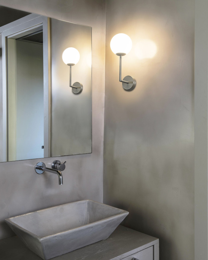 Silberne Wandleuchte aus Metallstruktur und Glasdiffusor hergestellt.