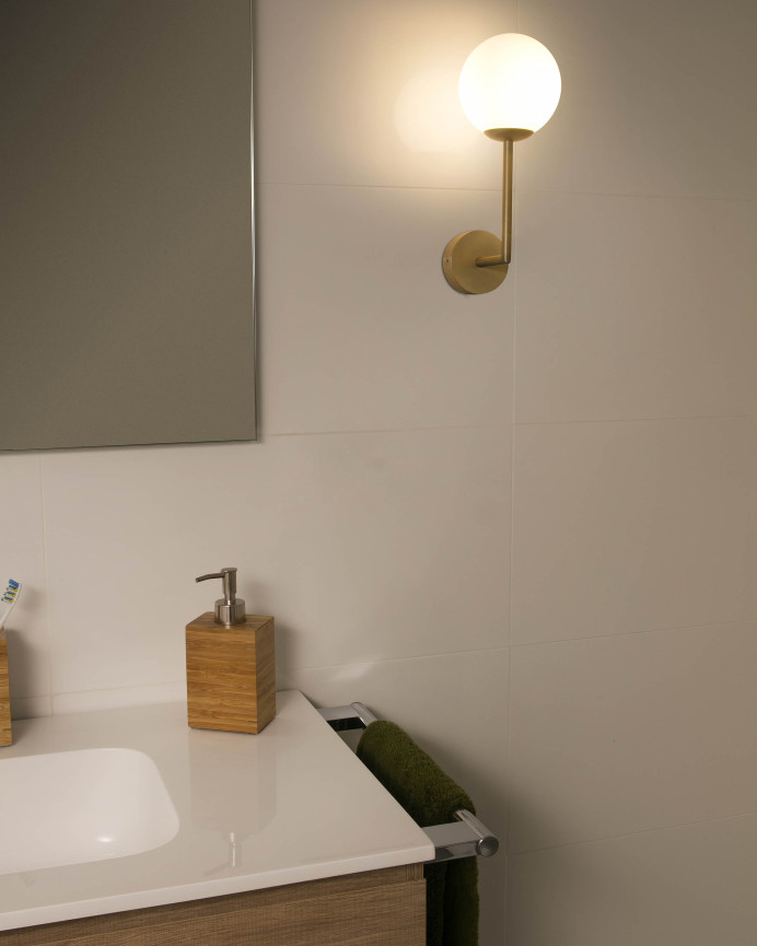 Goldene Wandlampe aus Metallstruktur und Glasdiffusor hergestellt.