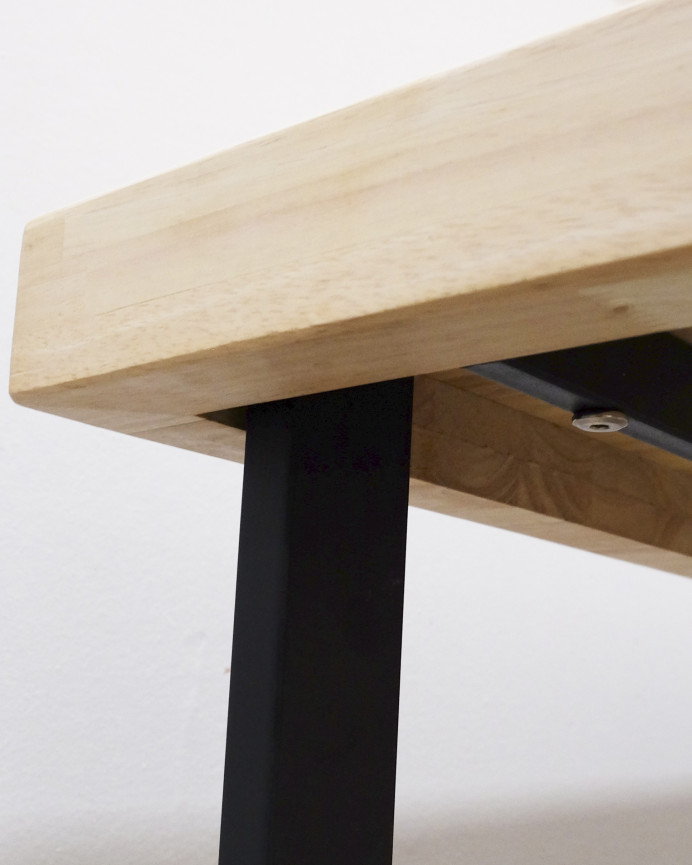 Massiver Holztisch mit naturbelassenem Finish und schwarzen Eisenbeinen in verschiedenen Größen.