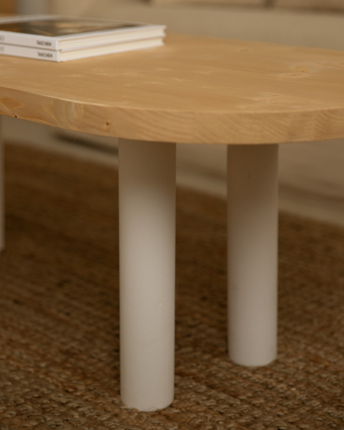 Ovaler Massivholz-Couchtisch in mittlerem Eichenholzton und weißen Beinen, 40x120 cm.