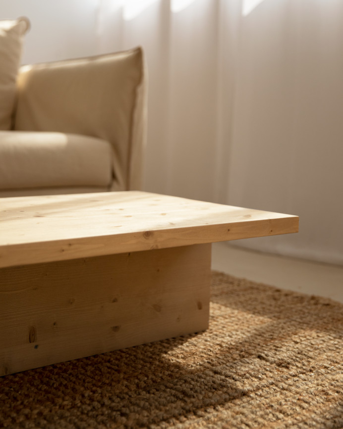 Massiver Couchtisch aus mittelbraunem Eichenholz im Maß 124x27cm.
