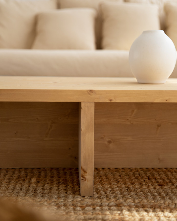 Massiver Couchtisch aus mittelbraunem Eichenholz im Maß 124x27cm.