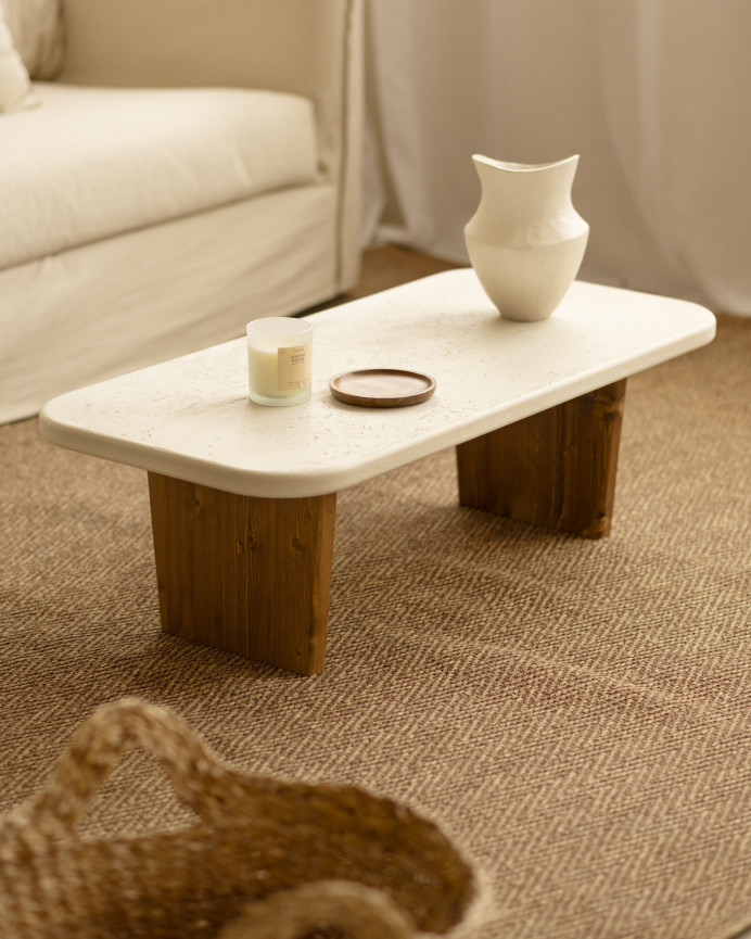 Couchtisch aus Mikrozement mit zwei dunkel gebeizten Holzbeinen, 95 cm lang.