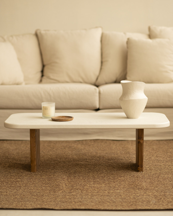 Couchtisch aus Mikrozement mit zwei dunkel gebeizten Holzbeinen, 95 cm lang.