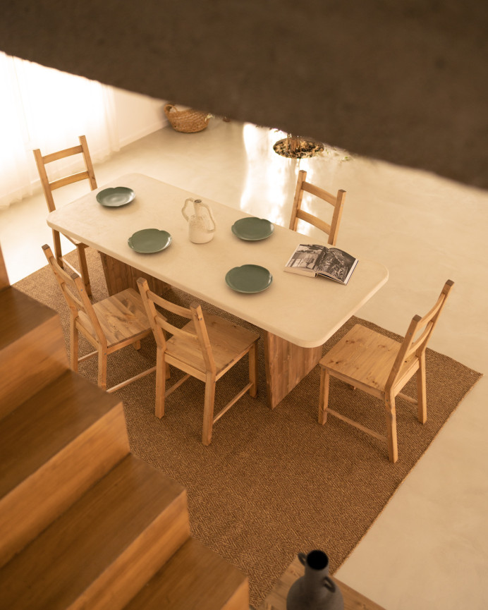 Esszimmertisch aus Microcement in gebrochenem Weißton mit dunkelroben Holzbeinen in verschiedenen Größen.