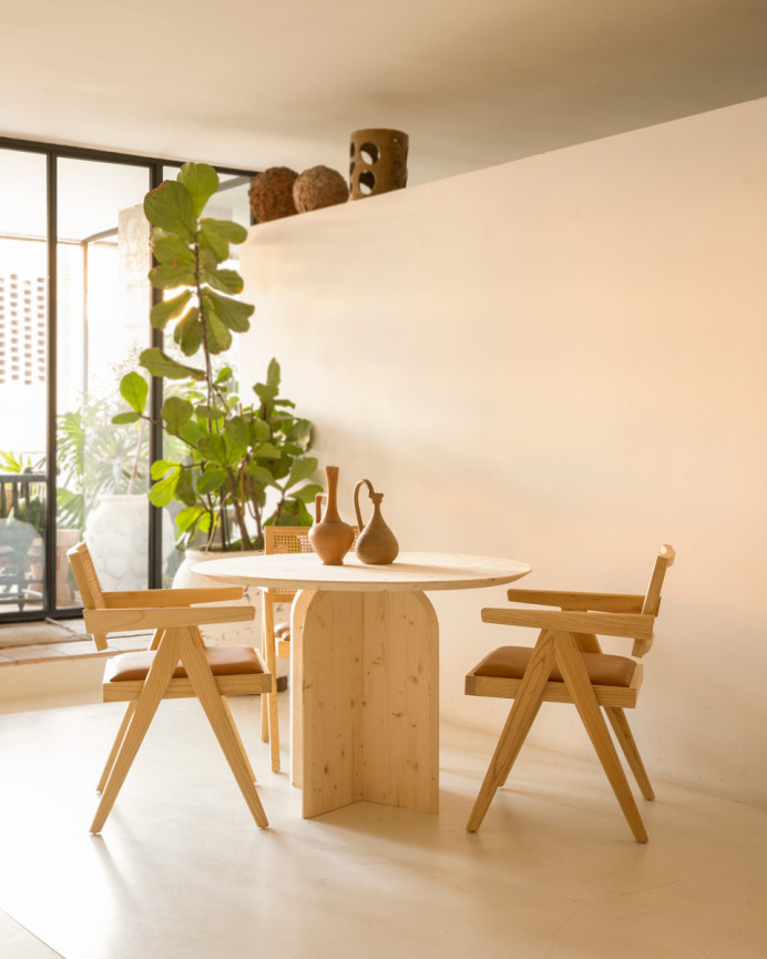Round solid wood dining table in a natural tone measuring 110cm.