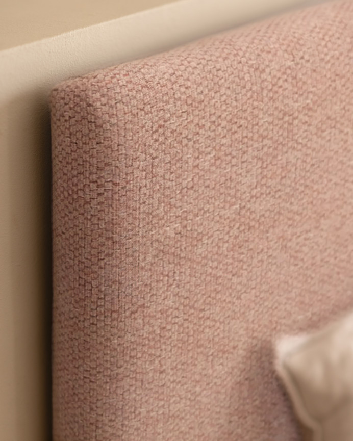 Upholstered headboard in plain polyester in pale pink color in various sizes.