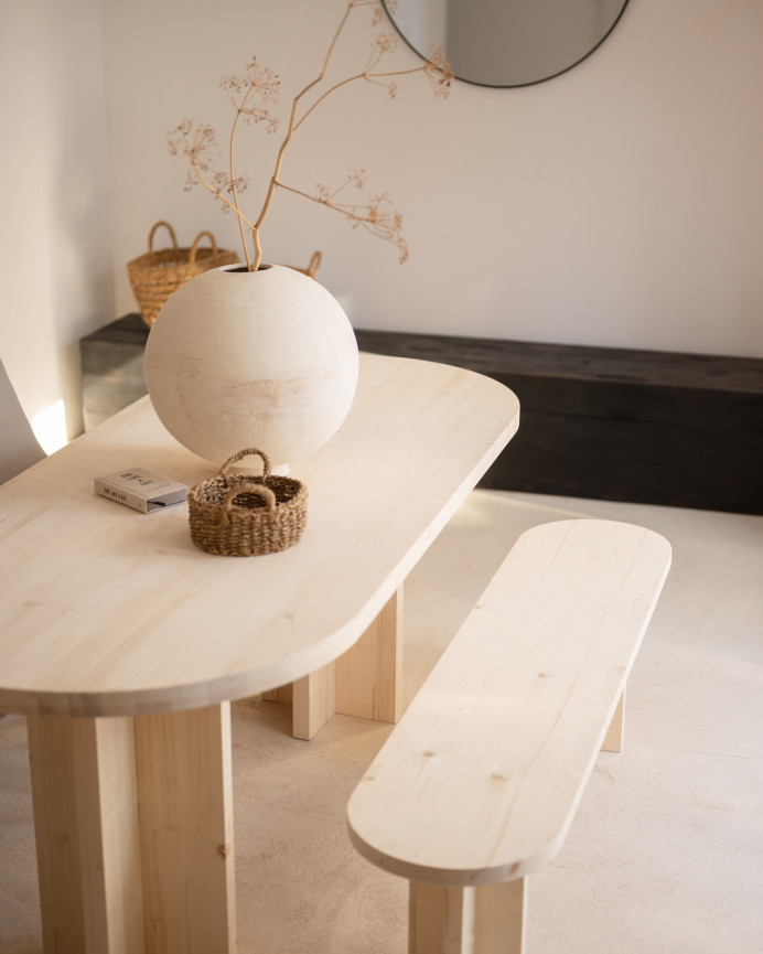 Oval solid wood dining table in natural tone available in various sizes.