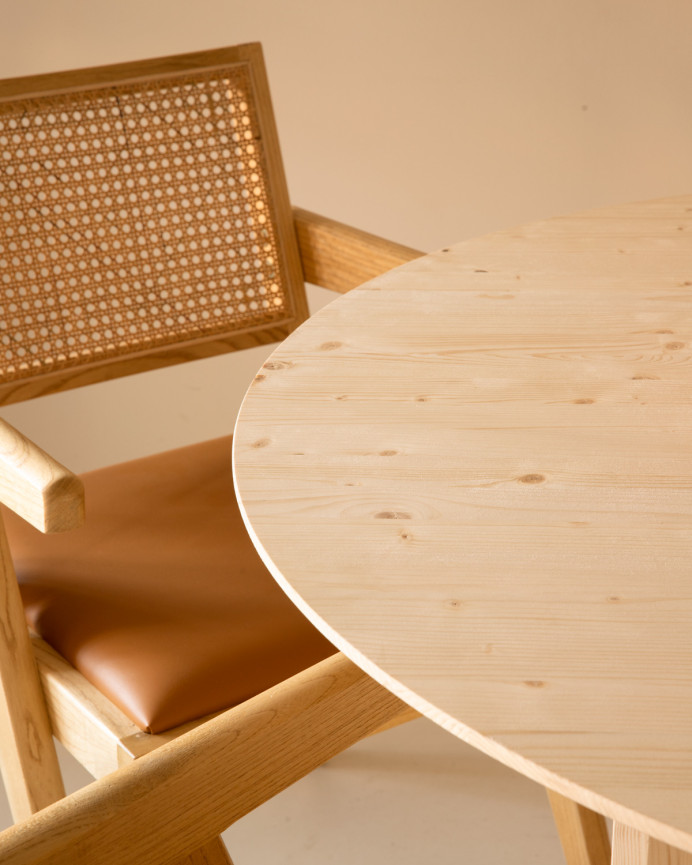 Round solid wood dining table in a natural tone measuring 110cm.