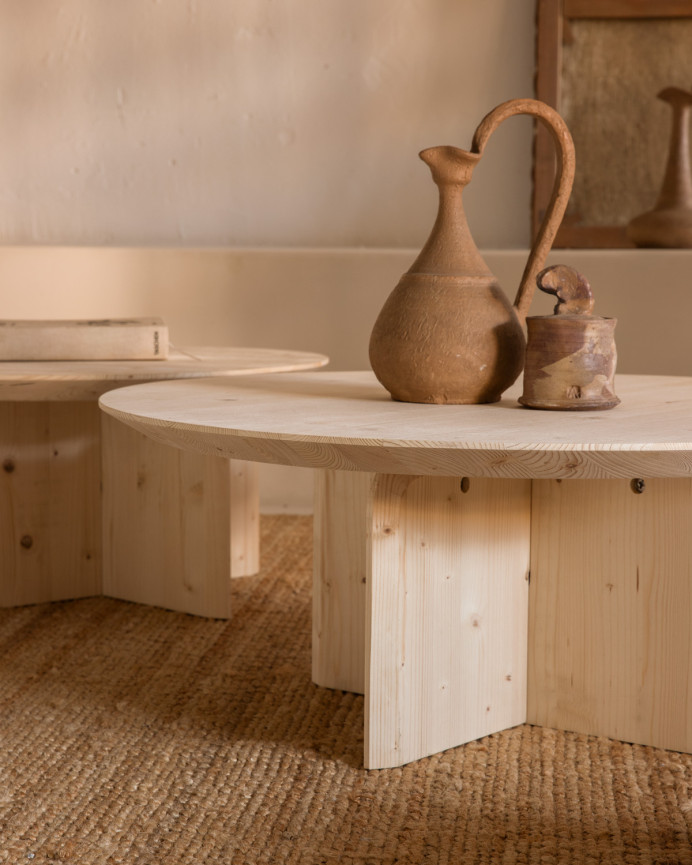 Round solid wood coffee table in natural tone available in various sizes.