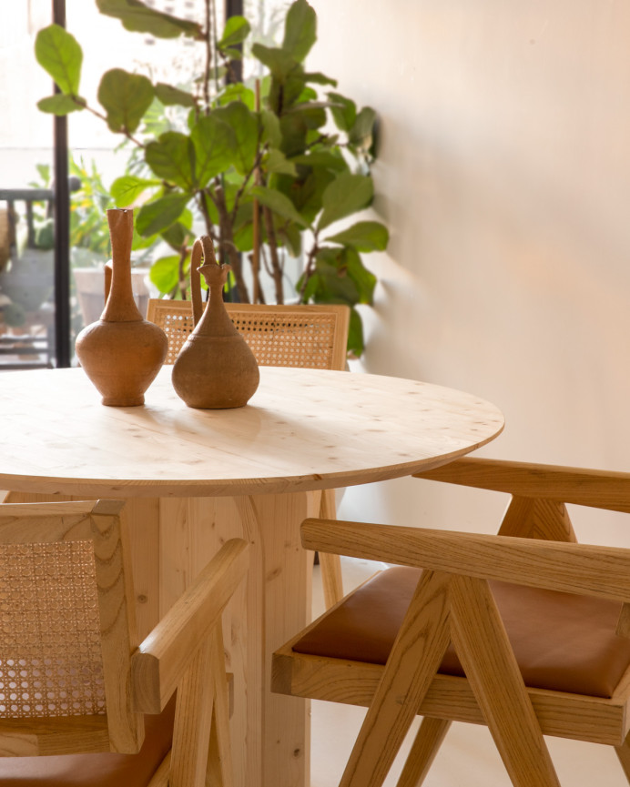 Round solid wood dining table in a natural tone measuring 110cm.