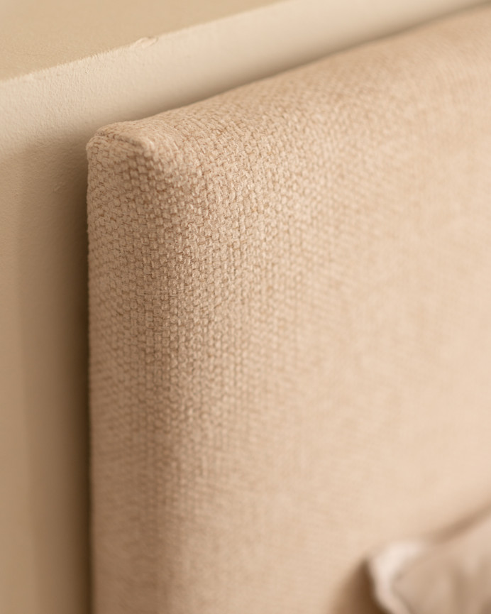 Set of upholstered beige headboard and 2 solid wood natural tone bedside tables in various sizes.