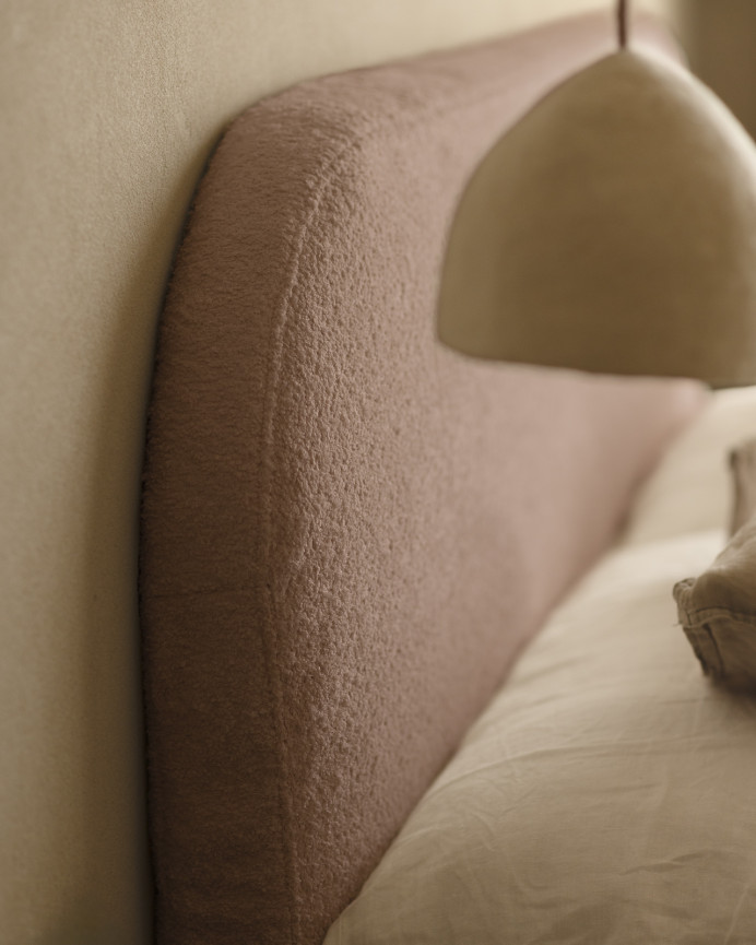 Upholstered headboard in removable pink bouclé fabric, available in various sizes.
