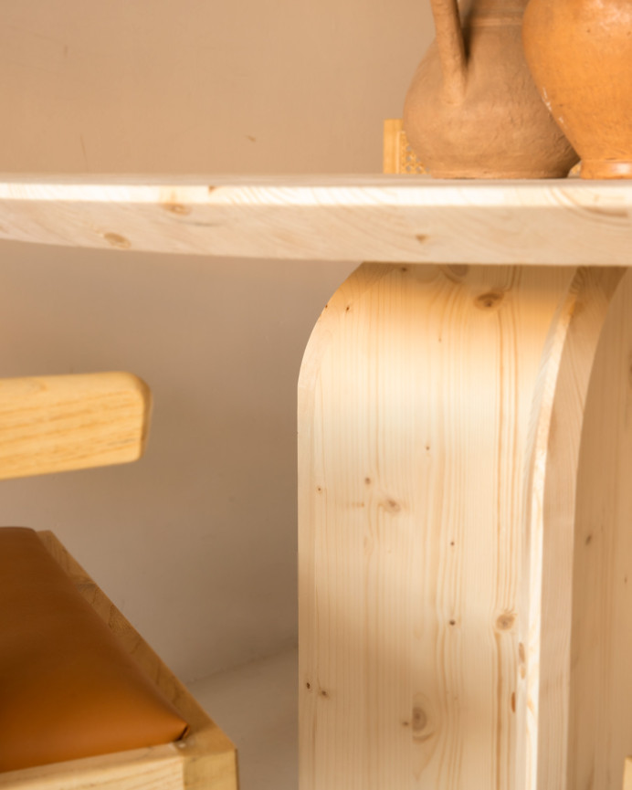 Round solid wood dining table in a natural tone measuring 110cm.