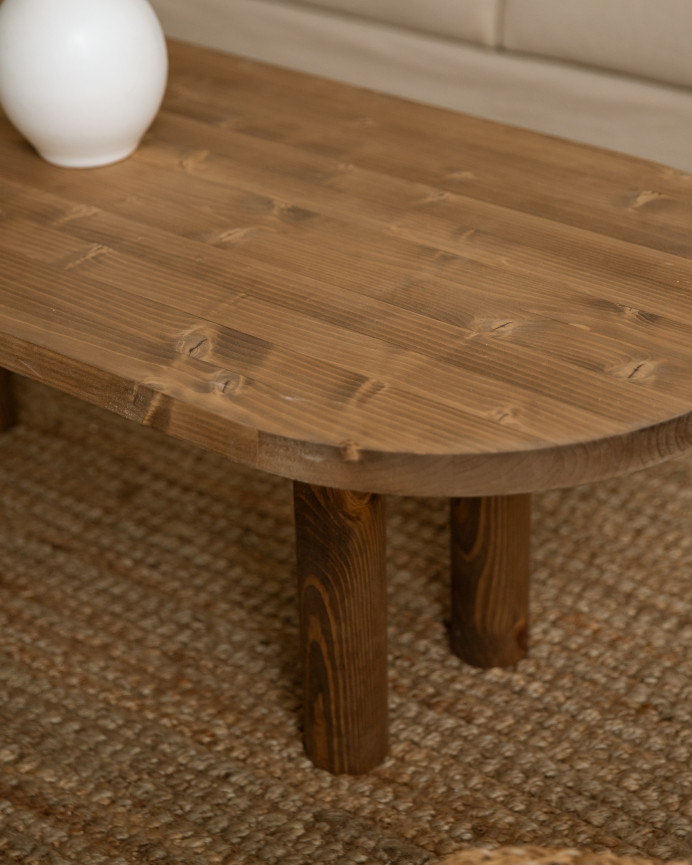 Solid wood oval coffee table in dark oak tone measuring 40x120cm.