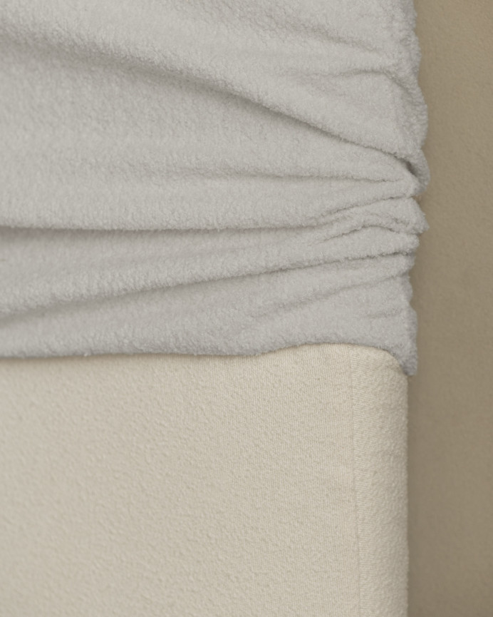 Upholstered headboard with removable light gray bouclé cover in various sizes.