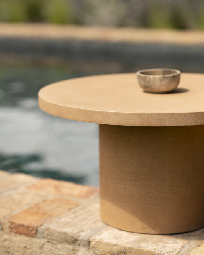 Round microcement coffee table in terracotta tone available in various sizes.