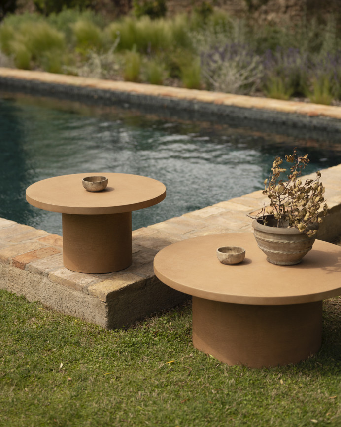 Round microcement coffee table in terracotta tone available in various sizes.