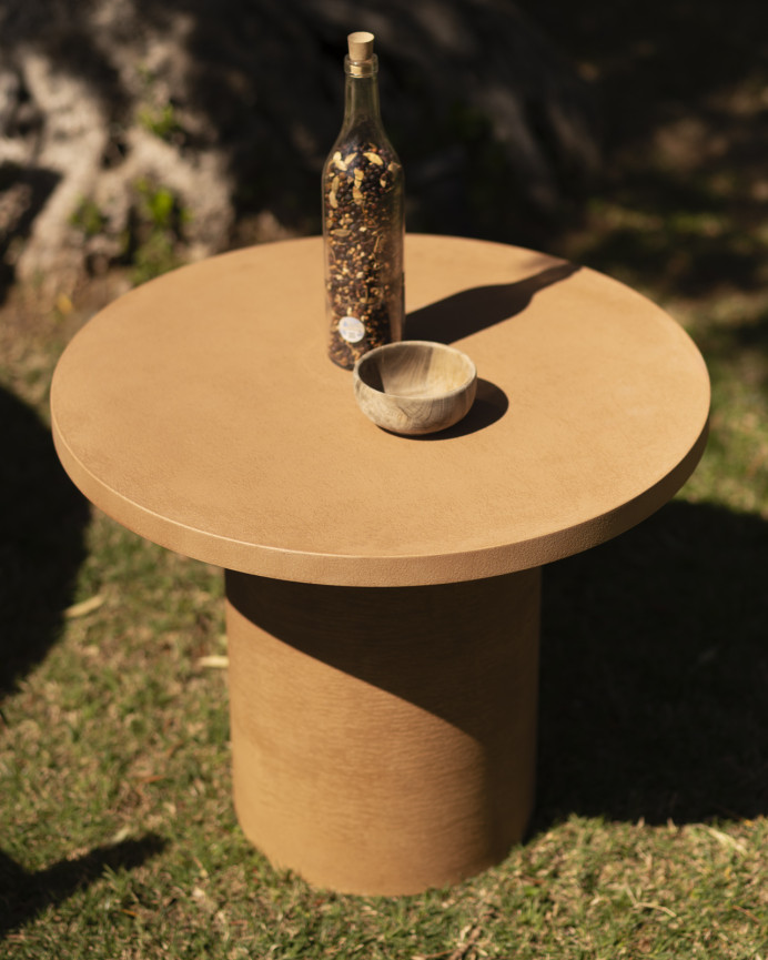 Round microcement coffee table in terracotta tone available in various sizes.