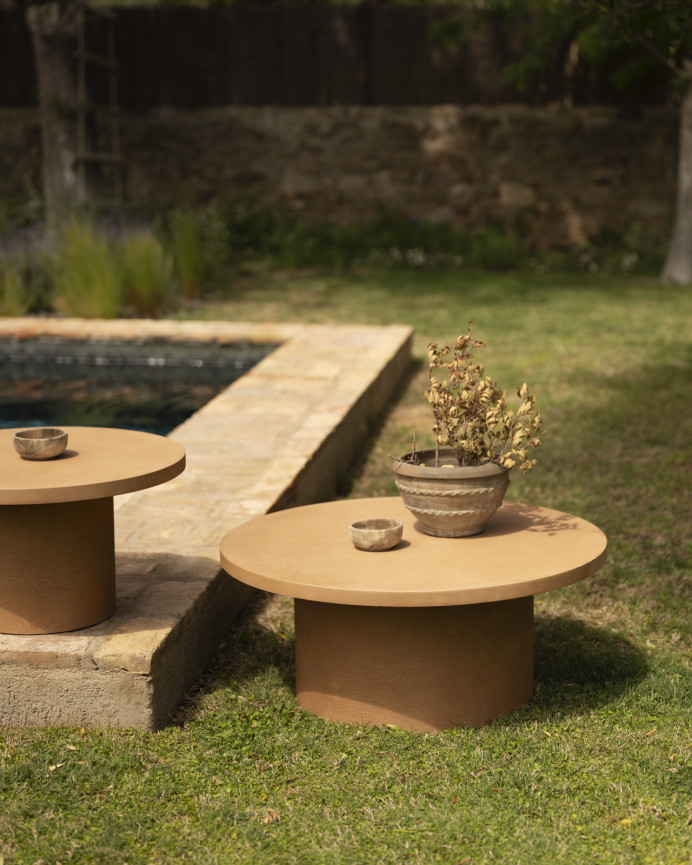 Round terracotta-colored microcement coffee table measuring 80x33cm.