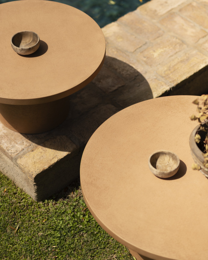 Round terracotta-colored microcement coffee table measuring 80x33cm.