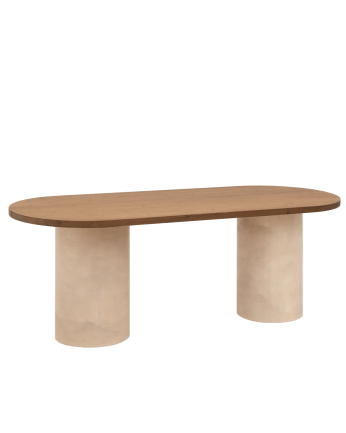 Oval dining table made of solid wood in a dark oak tone and micro cement legs in an earth tone, available in various sizes.