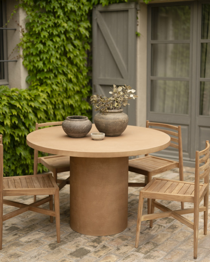 Round dining table made of terracotta-tone microcement in various sizes.