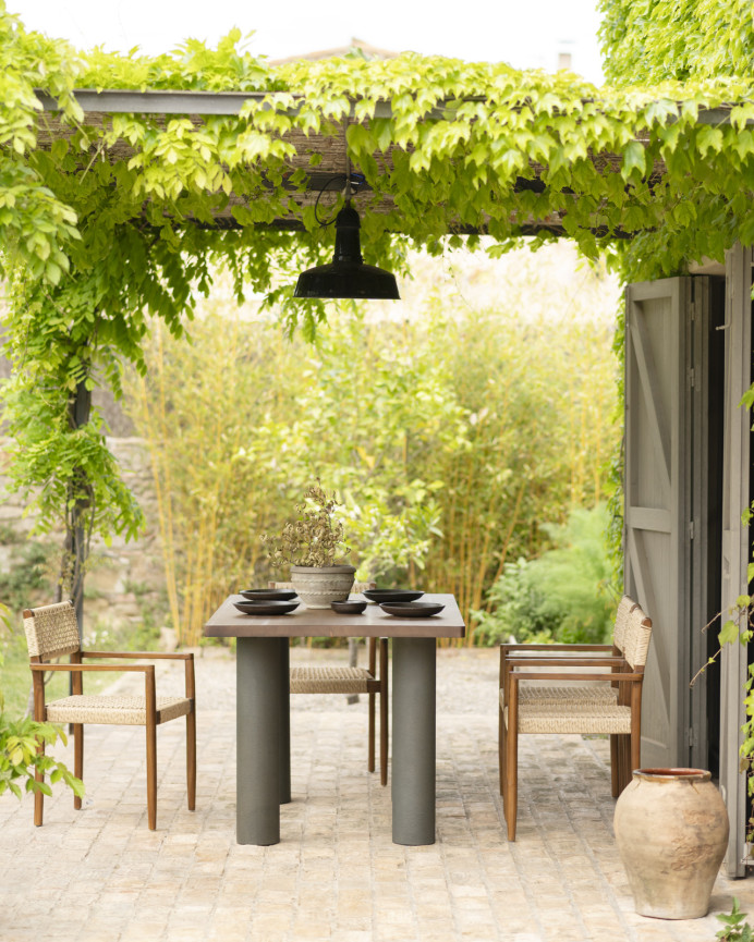 Solid wood dining table in a dark oak tone with microcement legs in a green shade available in various sizes.