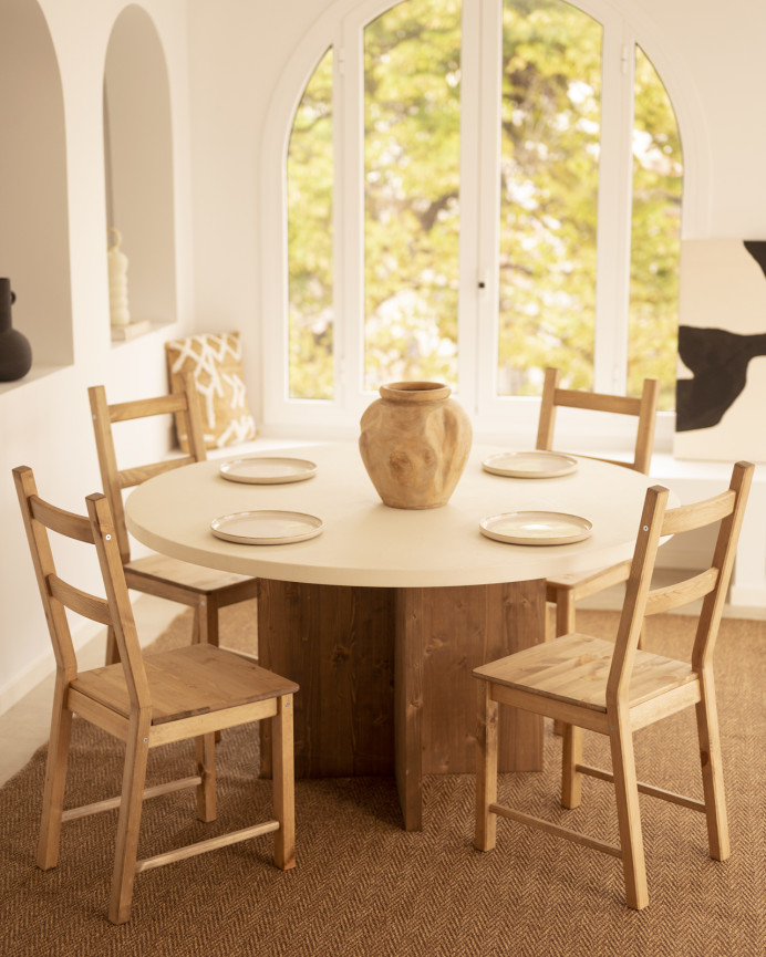 Round dining table made of white microcement with dark oak wood legs in various sizes.