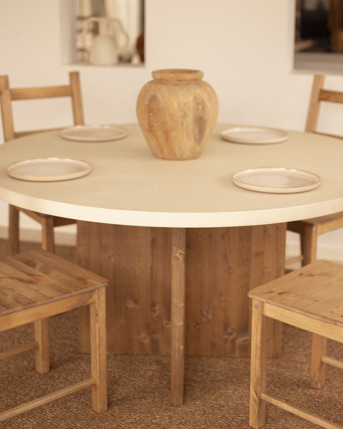 Round dining table made of white microcement with dark oak wood legs in various sizes.