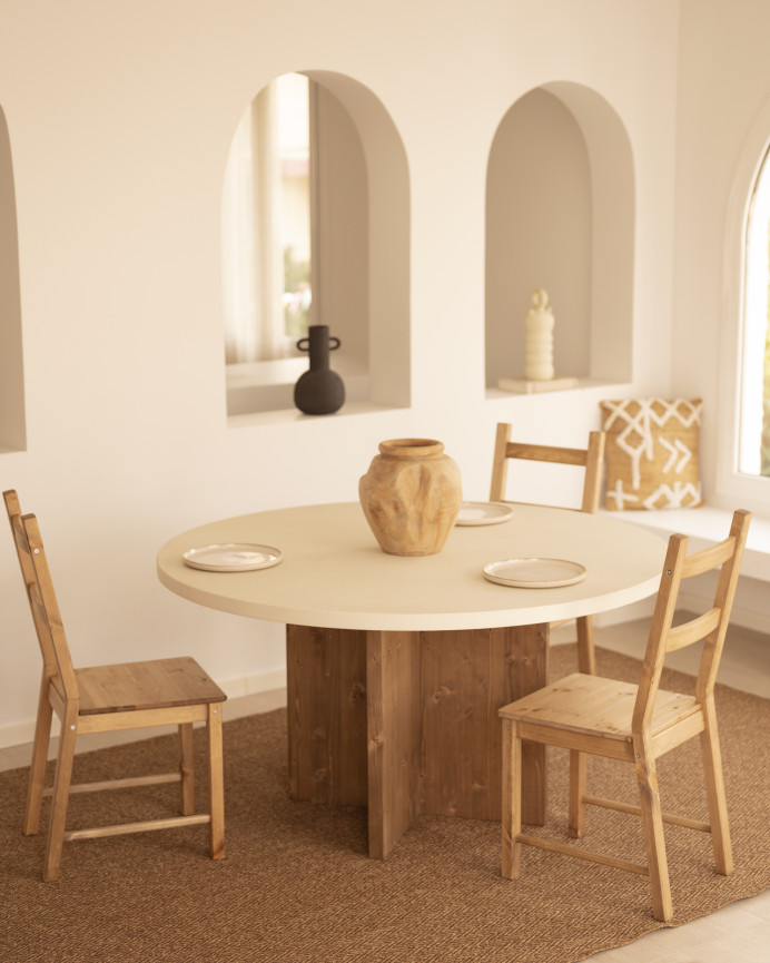 Round dining table made of white microcement with dark oak wood legs in various sizes.