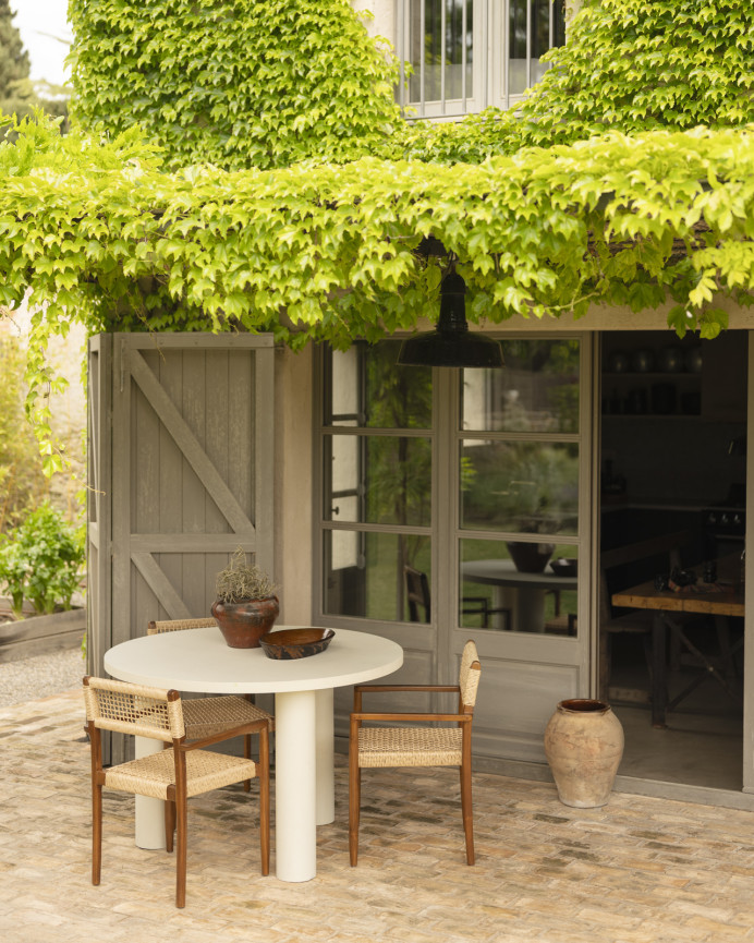 Round dining table made of microcement in off-white tone, available in various sizes.
