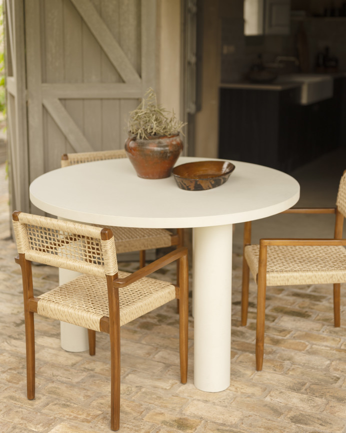 Round dining table made of microcement in off-white tone, available in various sizes.