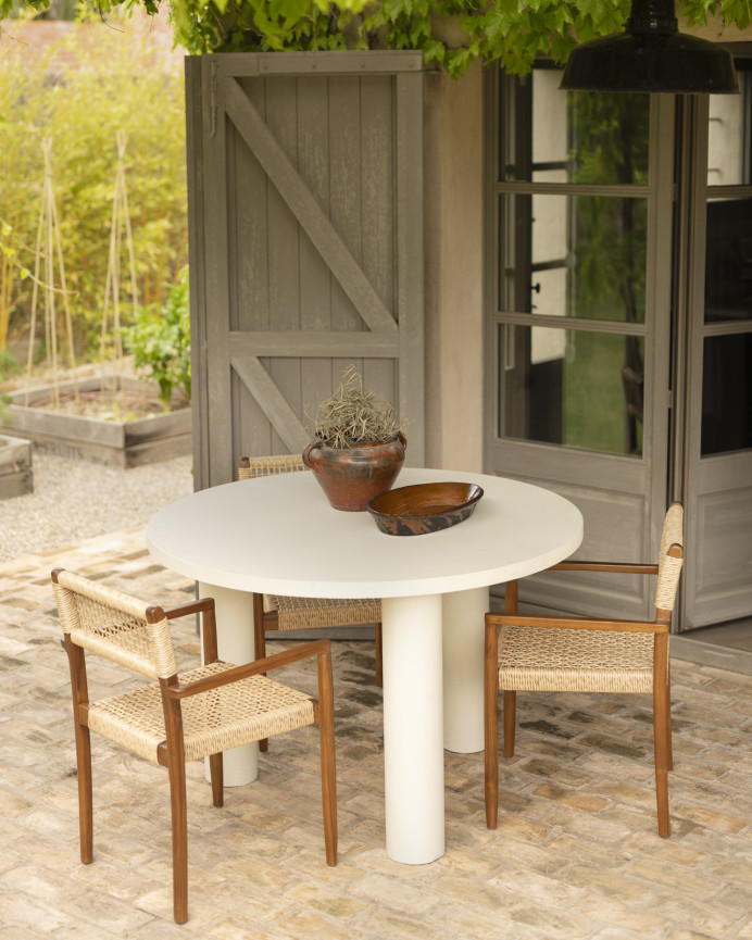 Round dining table made of microcement in off-white tone, available in various sizes.