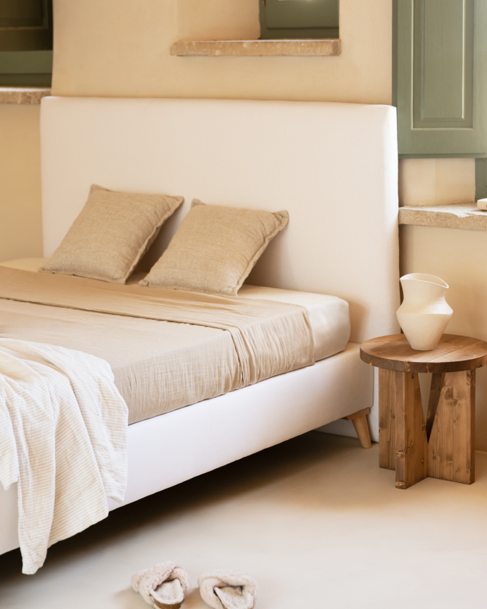 Upholstered white linen bed base for mattresses of various sizes.