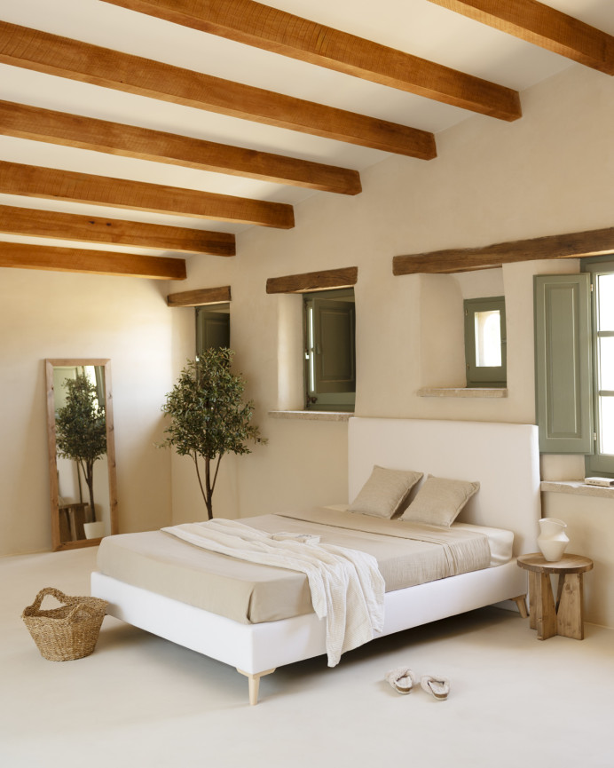Upholstered bed covered in white linen for a mattress of various sizes