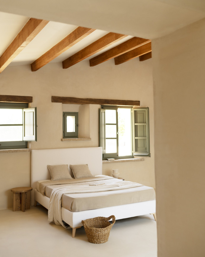 Upholstered bed covered in white linen for a mattress of various sizes