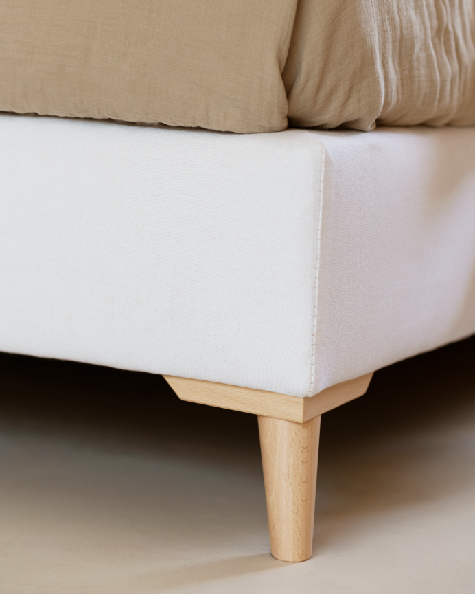 Upholstered bed covered in white linen for a mattress of various sizes