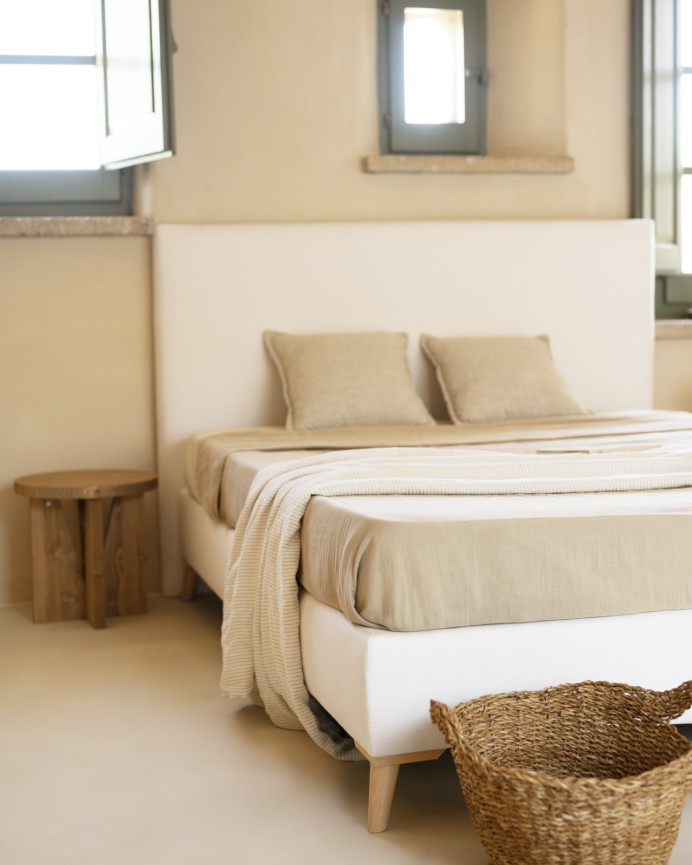Upholstered bed covered in white linen for a mattress of various sizes