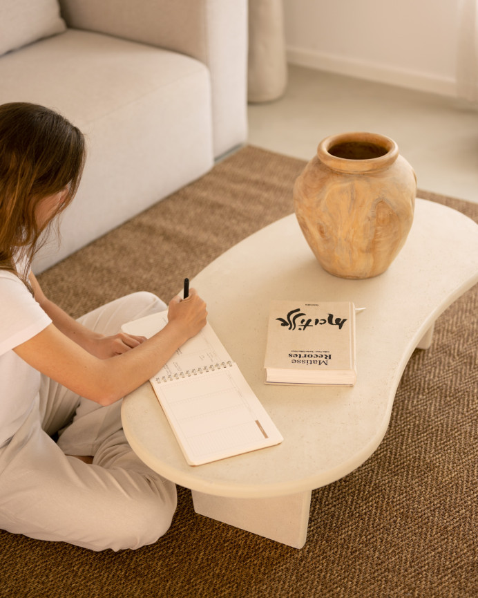 Organic-shaped microcement coffee table with three legs in off-white tone, measuring 120cm.