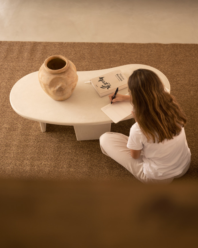 Organic-shaped microcement coffee table with three legs in off-white tone, measuring 120cm.