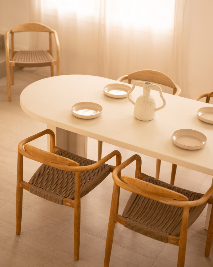 Oval dining table made of microcement in a off-white color, available in various sizes.