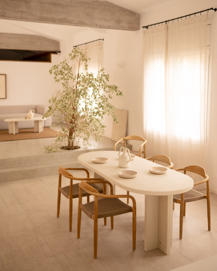 Oval dining table made of microcement in a off-white color, available in various sizes.