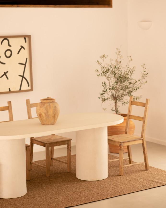 Oval dining table made of micro cement in a light off-white tone, available in various sizes.