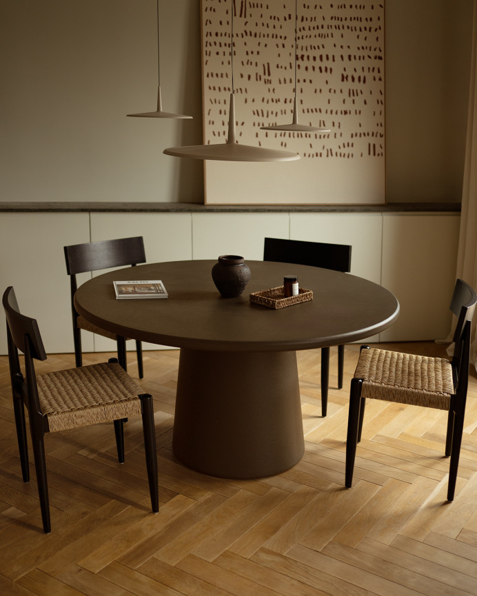 Round dining table made of brown microcement in various sizes