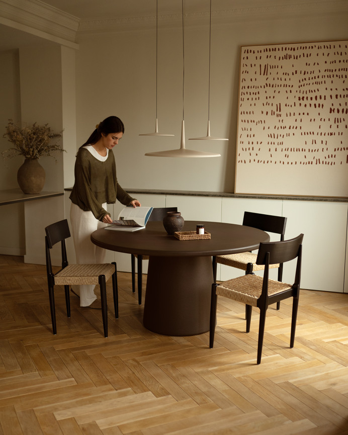 Round dining table made of brown microcement in various sizes