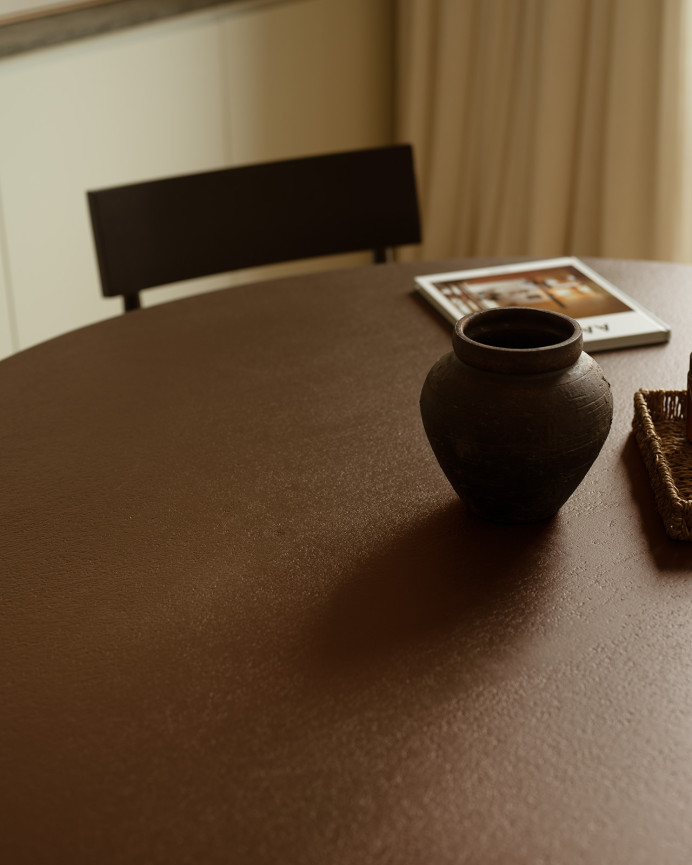 Round dining table made of brown microcement in various sizes