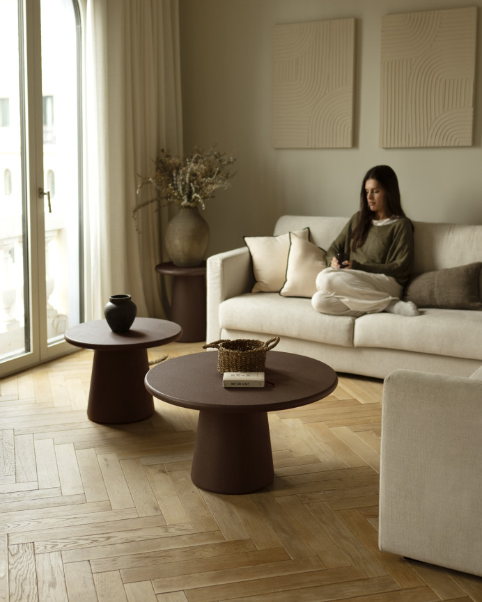Round coffee table made of microcement in brown tones available in various sizes.