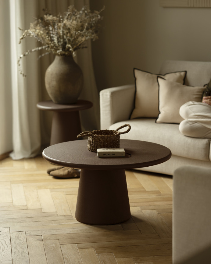 Round coffee table made of microcement in brown tones available in various sizes.