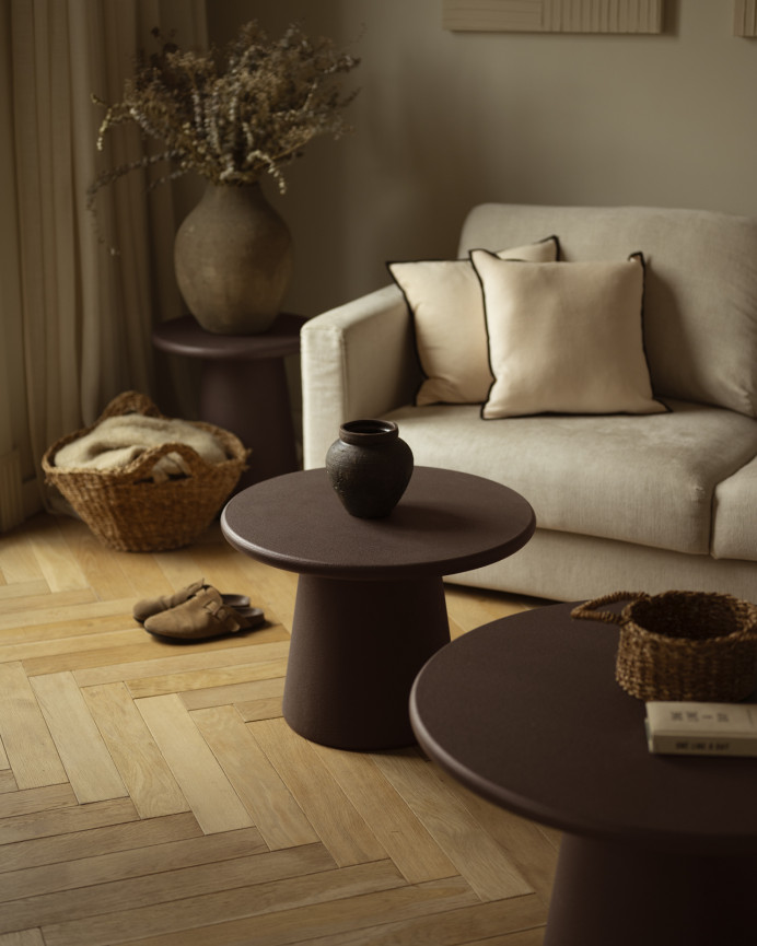 Round coffee table made of microcement in brown tones available in various sizes.